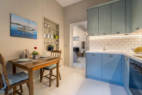 cocina con armarios azules y mesa de madera en Lucas Apartment en Lixouri
