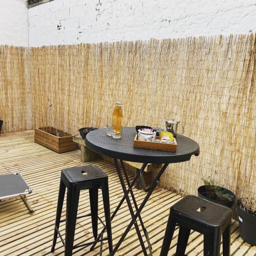 - une table avec deux tabourets noirs et une boisson dans l'établissement Le beffroi, à Calais