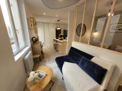 a living room with a blue couch and a table at Appartement charmant au cœur de la cité bragarde in Saint-Dizier