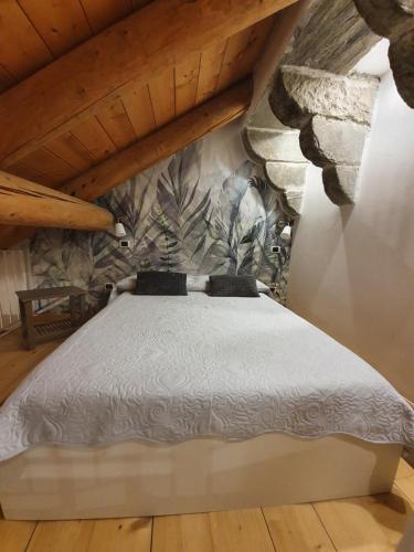 a bed in a room with a stone wall at Torre del Moro in Domodossola