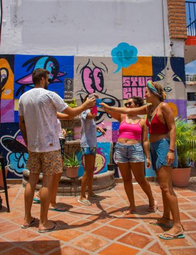 a group of people standing in front of a wall with graffiti at Chanclas Hostel Vallarta in Puerto Vallarta