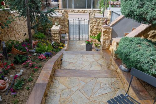 a garden with a stone walkway and flowers at Villa Joanna 2 in Thessaloniki