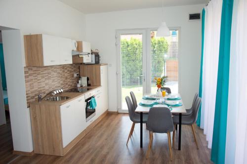 a kitchen with a table with chairs and a sink at Villa Aquamarine in Balatonboglár