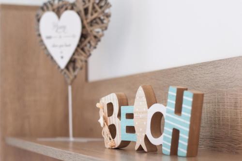 a wooden sign that says love sitting on a shelf at Villa Aquamarine in Balatonboglár