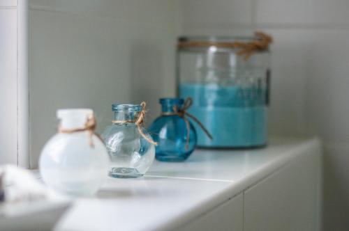 trois vases bleus en verre assis sur un comptoir dans l'établissement Villa Aquamarine, à Balatonboglár