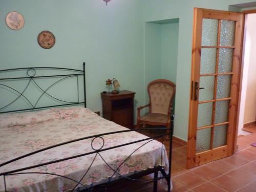 ein Schlafzimmer mit einem Bett, einem Tisch und einem Stuhl in der Unterkunft Casa Cossu in Sorso