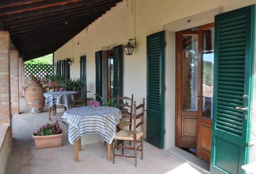 a patio with two tables and chairs and a door at Hotel Villa Casalecchi in Castellina in Chianti