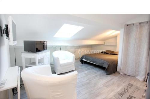 - une chambre avec un lit et une chaise blanche dans l'établissement Appartements Cannes Centre Ville, à Cannes