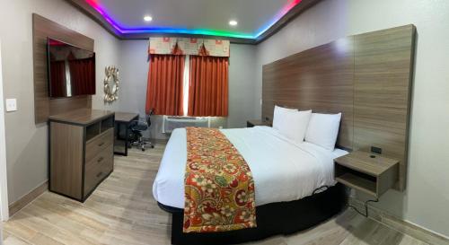 a hotel room with a bed and a desk at BuZen Suites Las Colinas in Dallas