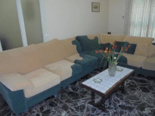a living room with a couch and a table with flowers at Paraskevi's House in Argos