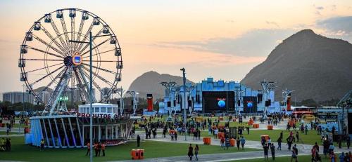 a carnival with a ferris wheel and a crowd of people at MELHOR Localização na Barra da Tijuca- Apartamento com Ar, wifi, microondas in Rio de Janeiro