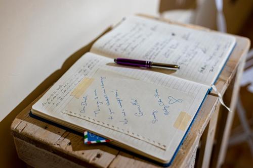 a notebook and a pen on a wooden table at Trapani Home in Trapani