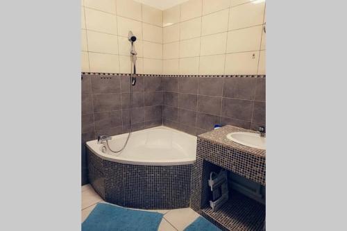 une salle de bain avec une baignoire et un lavabo dans l'établissement le T3 à 600mètre du vieux port proche de la gare, à Marseille