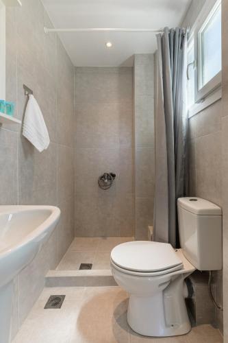 a bathroom with a white toilet and a sink at V Luxury Apartments Posidi in Possidi