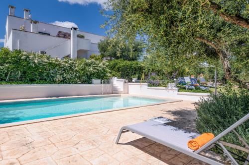 a swimming pool with a bench next to a building at La Casèdde in Cisternino
