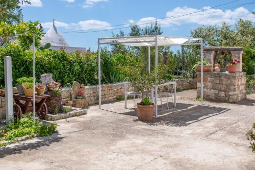 a garden with an umbrella and some plants at La Casèdde in Cisternino