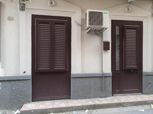 zwei braune Türen an der Seite eines Gebäudes in der Unterkunft La Casetta in Palermo