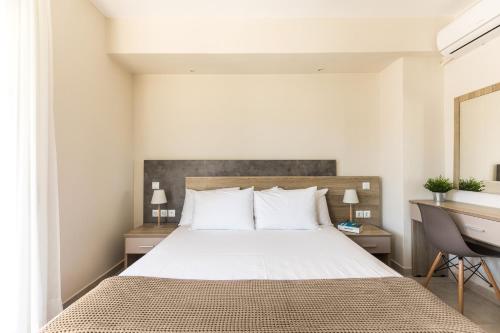 a bedroom with a large bed and a desk at V Luxury Apartments Posidi in Possidi