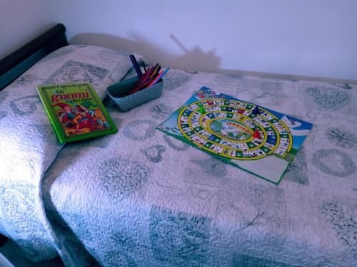a table with a bed with a book and some pens at Bassano Up in Mussolente 