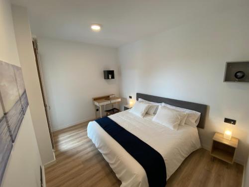 - une chambre dotée d'un grand lit avec des draps et des oreillers blancs dans l'établissement Vianetto Home, à Monzón