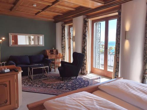 a bedroom with a bed and a living room at Hotel Strand-Cafe direkt am Bodensee in Meersburg