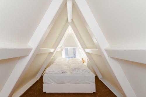 a bed in a room with a roof at B&B The Catch Apartment in Amsterdam