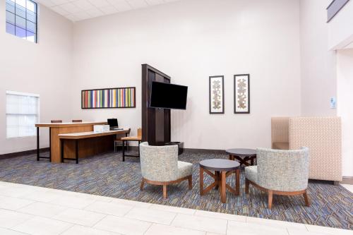 a waiting room with a table and chairs and a desk at Holiday Inn Express & Suites - Morehead City by IHG in Morehead City