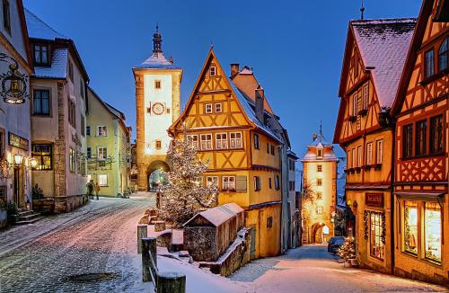 a city street with buildings and a christmas tree at Hotel Sonne - Das kleine Altstadt Hotel in Rothenburg ob der Tauber