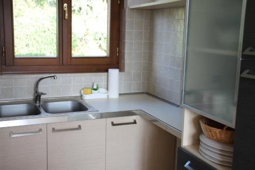 een kleine keuken met een wastafel en een raam bij Casa Cecilia, 2 bedrooms, 1 bathroom, lake view, pool in Gardone Riviera