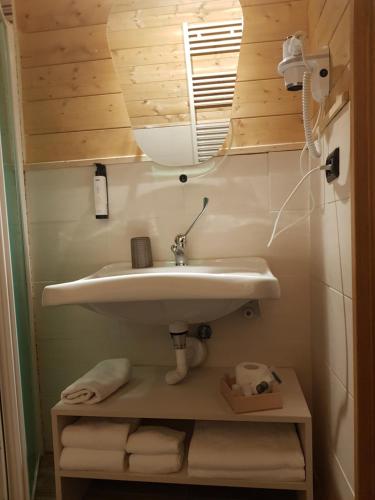 a bathroom with a sink and a mirror and towels at Lorica Suite Lago in Lorica
