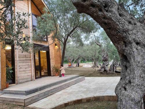 een klein meisje buiten een huis bij OLEA COTTAGE in Ulcinj