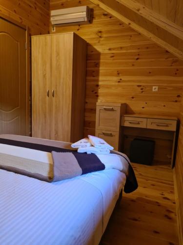 a bedroom with a bed in a log cabin at OLEA COTTAGE in Ulcinj