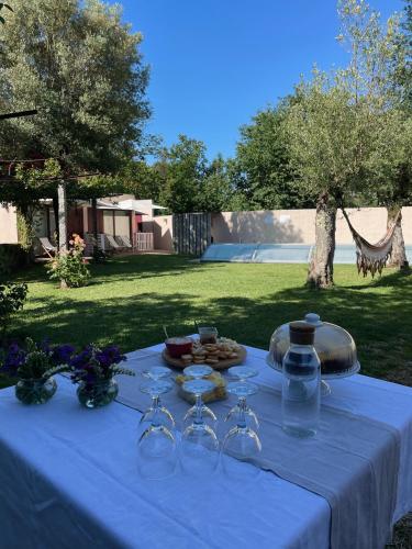 a white table with wine glasses and food on it at Eido do Luou - Casa de férias com piscina in Santa Cruz do Lima
