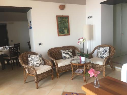 sala de estar con sillas de mimbre y mesa en Villa L' Eco dell' 800, en Furore