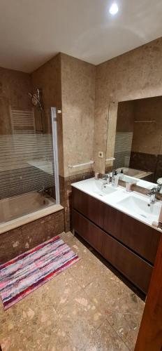 a bathroom with a tub and a sink and a shower at Apartamento Francelos Condominio in Vila Nova de Gaia