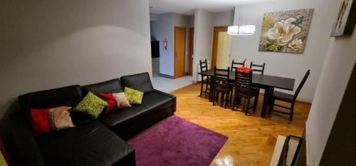 uma sala de estar com um sofá preto e uma mesa em Apartamento Francelos Condominio em Vila Nova de Gaia
