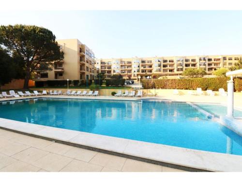 a large blue swimming pool with white chairs and buildings at Apartamento Francelos Condominio in Vila Nova de Gaia