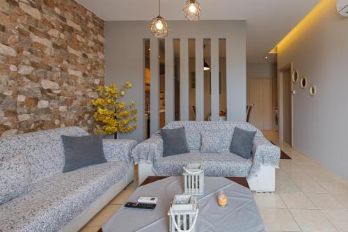 a living room with two couches and a brick wall at Villa Joanna in Thessaloniki