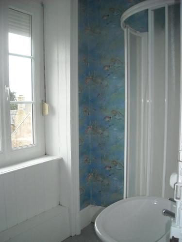 une salle de bain avec toilettes, lavabo et fenêtre dans l'établissement Simadline, à Sartilly