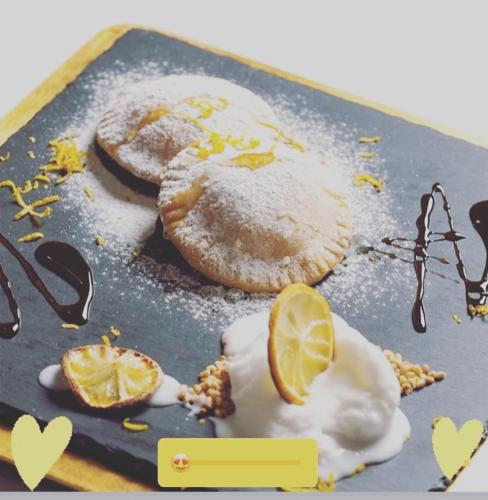 a plate with two pastries with sugar and lemon slices at Il Nuraghe del lago Coghinas in Oschiri