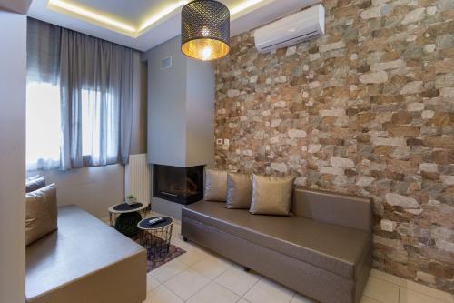 a living room with a couch and a brick wall at Villa Joanna in Thessaloniki