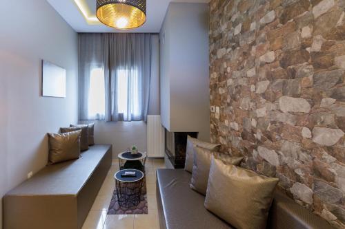 a living room with a couch and a stone wall at Villa Joanna in Thessaloniki