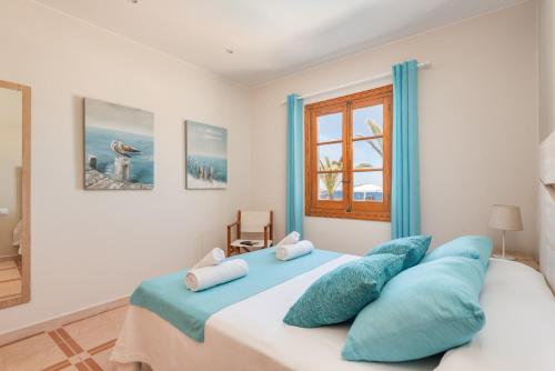 a bedroom with a large bed with blue pillows at Villa Lali in Punta Grossa
