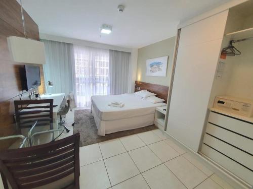 a bedroom with a bed and a bathroom with a sink at Flat Hotel Fusion com estacionamento grátis D21 in Brasilia