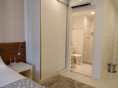 a bedroom with a glass shower and a toilet at Flat Hotel Fusion com estacionamento grátis D21 in Brasilia