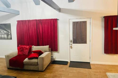 a living room with a couch and red curtains at Comtemporary, Confortable, Well Appointed Home. in Tobyhanna