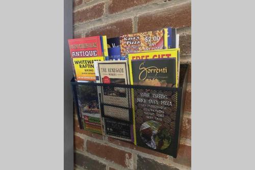 a shelf filled with books on a brick wall at Comtemporary, Confortable, Well Appointed Home. in Tobyhanna