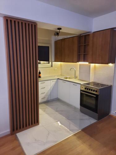 a kitchen with white cabinets and a sink and a stove at N&A Apartment in Ohrid