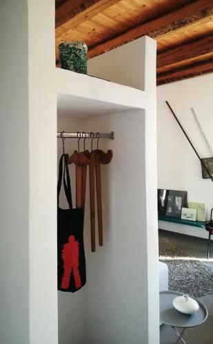 a room with a white wall with a shelf with baseball bats at Ritrovo dell'acqua _ Efesto in Casacalenda