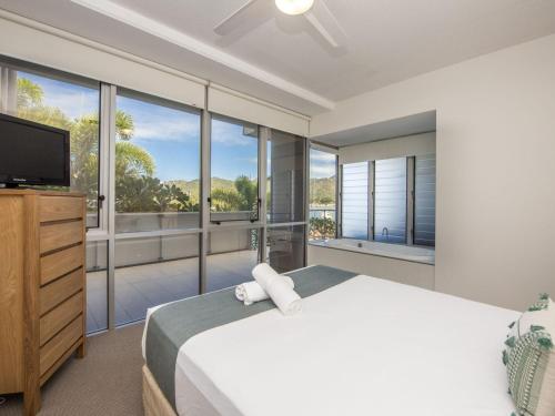 a bedroom with a large bed and large windows at 1 Bright Point Apartment 2204 in Nelly Bay